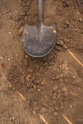 Old dirty shovel in the ground on the garden bed. gardening tool and equipment. concept of garden work at summer or spring. Top view. 