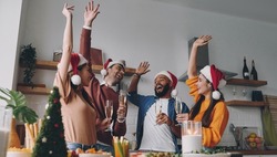Group of young people having fun while enjoying Christmas dinner at home together