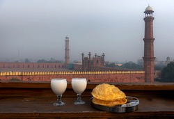 traditional breakfast in food street lahore, badshahi masjid is in background ,
walled city in fog , food street of Lahore 