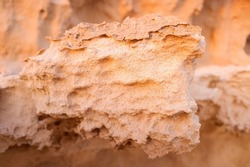 Close-up of a rock being eroded by fine sand.