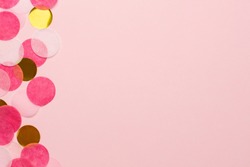 Golden and pink confetti on pink color paper background minimal style macro view with copyspace