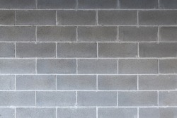 Cement concrete grey brick wall backdrop with symmetrical lines, urban background, cinderblock texture