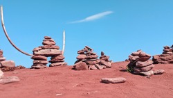 Dozens of Inuksuit rock statues cover the red sand beaches of North Cape, a  destination just north of Tignish, PEI. Of interest in this photo is the Inukshuk with horns used as part of its assembly.
