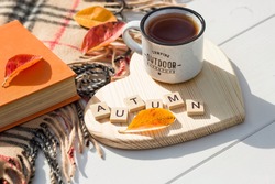 Coffee mug and wooden letters on a wooden stand in the shape of a heart on a white table. The concept of the fall season. A Cup of tea with autumn leaves. fall time. Copy space.