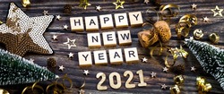 Banner.Happy New Year 2021. A symbol from the number 2021 with Golden balls, stars, sequins and a beautiful bokeh on a wooden background. The concept of the celebration.