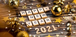 Banner.Happy New Year 2021. A symbol from the number 2021 with Golden balls, stars, sequins and a beautiful bokeh on a wooden background. The concept of the celebration.