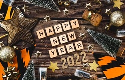 Banner. A symbol from the number 2022 with golden balls, stars, sequins and tiger print on a wooden background. The concept of celebrating a Happy New Year and Christmas.