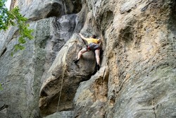 A rock climber climbs a rock. The climber trains on natural terrain. A man trains strength and endurance.  Active lifestyle. Extreme sports. Rock climbing in Carpath.
