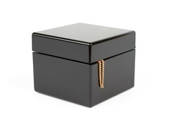Black plastic glossy box isolated with gold chain sticking out on white