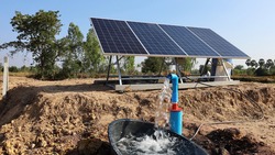 Water pumps and solar panels. Groundwater is pumped with a submersible pump from clean energy or solar energy converted to electric energy on an agricultural farm with a copy area. Selective focus