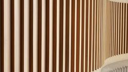 Sunlight and shadows on the surface of the wooden slats on the wall. Abstract wood background made by vertical incident light for background design with copy space. Selective focus