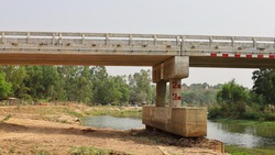 Bunting with concrete bridge poles. Cement pier base and above-ground columns of the bridge for crossing rivers in the dry season on white sky background with copy space. Selective focus