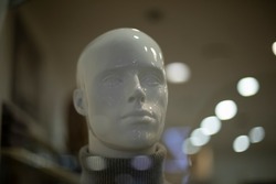 Mannequin in clothing store. Man's head. White figure. Face of person made of plastic.
