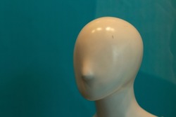The face of the mannequin without details. Plastic head to show clothes. Mannequin with nose. The absence of eyes and ears on the head of the sculpture.