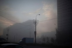 Building is in fog. City in morning. Tall building in morning haze. Cityscape. Blurry picture. House behind veil.