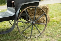 Vintage wheel. Large carriage wheel. Black carriage of bygone era. Vintage transport. Details of countryside.