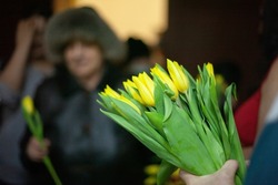 Yellow flowers in hands. Bouquet of flowers for artist. Guests after event. Meeting friend.
