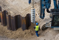 installing sheet piling on construction site with drilling rig