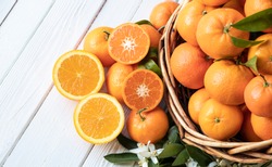 Orange fruit with green leaves on the white wood.  Home gardening. Mandarine oranges. Tangerine  oranges. Orange color. Fresh orange juice.