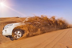 Offroad vehicle bashing through sand dunes in the desert