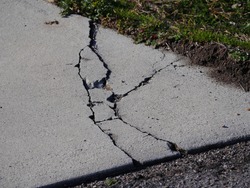 Cracks in concrete driveway, sunken areas caused by heavy equipment or settling