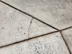 Cracks in driveway caused by settlement or heavy equipment. Crack stopped by control joint