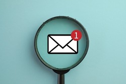 New Email ,massage,unread email Concept.,View through a magnifying glass on Email Alert icon over blue pastel background.