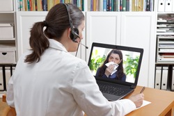 Telemedicine concept: doctor or pharmacist with headset during a video consult with a patient with the flu.