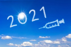Healthy New Year concept. 2021 text and syringe icon on blue sky, signifying an end to the covid pandemic.