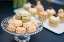 French cakes macaron or macaroon. Lightbrown macarons on a glass plate,