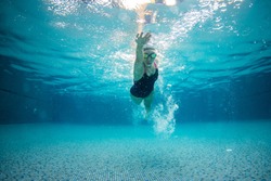 underwater picture of swimming woman in the pool.
