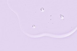 Lavender oil texture. Lquid puddle with bubbles on violet color background. Essential oil, serum, cosmetic product macro