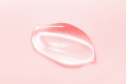 Beauty serum gel drop on pink background. Clear skincare product with bubbles texture macro