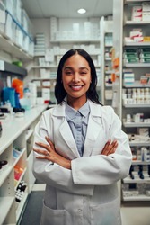 Portrait of smiling young african american woman pharmacist wearing labcoat standing in chemist