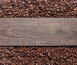 Coffee beans and wooden texture background.