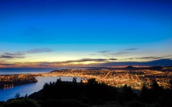 Hill top view of Dunedin City. From the top, one can enjoy beautiful city lights, sunset and colorful sky. Dunedin is a popular tourist destination in South Island of New Zealand.