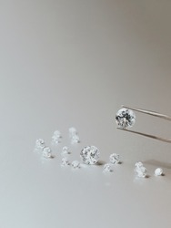 A round brilliant cut diamond held in tweezers