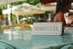 Reserved sign in Spanish language on empty table in outdoor terrace, Madrid, Spain. Concept of restaurant business and hospitality sector recovery after covid19 pandemic