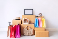 Colorful shopping bag with stack of cardboard boxes and fashion items at home, Website online shopping concept with copy space