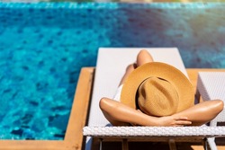 Young woman traveler relaxing at the resort pool while traveling for summer vacation