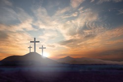 Three crosses on the mountain Jesus Christ with a sunset background