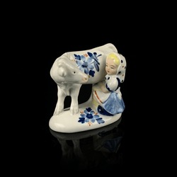 Antique porcelain figurine of a elephant on a black background. antique porcelain figurine of a girl and a cow