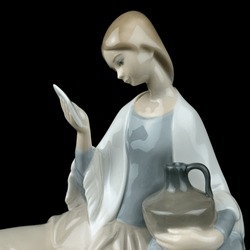 Statue of Virgin Mary isolated on black background, clipping path included. vintage figurine of a woman reading a book