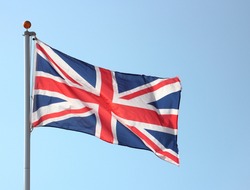 Union Jack flag blowing in the wind on flag pole
