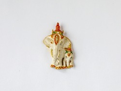 Fridge magnet souvenir in shape of two decorated white and golden elephants isolated on white background. Travel to Thailand concept. Top view flat lay close up, copy space
