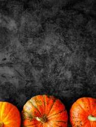 Halloween background with orange pumpkins border on black marble. Happy Halloween holiday sale, discount, promotion banner template. Top view, copy space, vertical