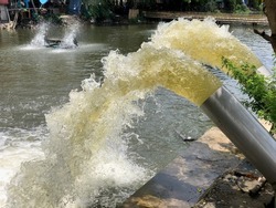 Blurred water spout from pump pipe to canal after heavy rain in Thailand.Rain water pumping out through water pump into canal with prevention for flood.