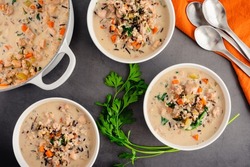 Bowls of Chicken and Wild Rice Soup: Overhead view of creamy chicken and wild rice soup with spinach and carrots