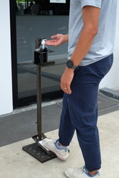 Close up picture of a man used foot operated hand sanitizer dispenser or hands free sanitizer stand at pubic area. Touchless equipment. cleaning and protect from Covid-19, Corona virus disease.