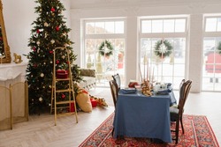 Christmas decor in the living room with large windows, dining table and Christmas tree